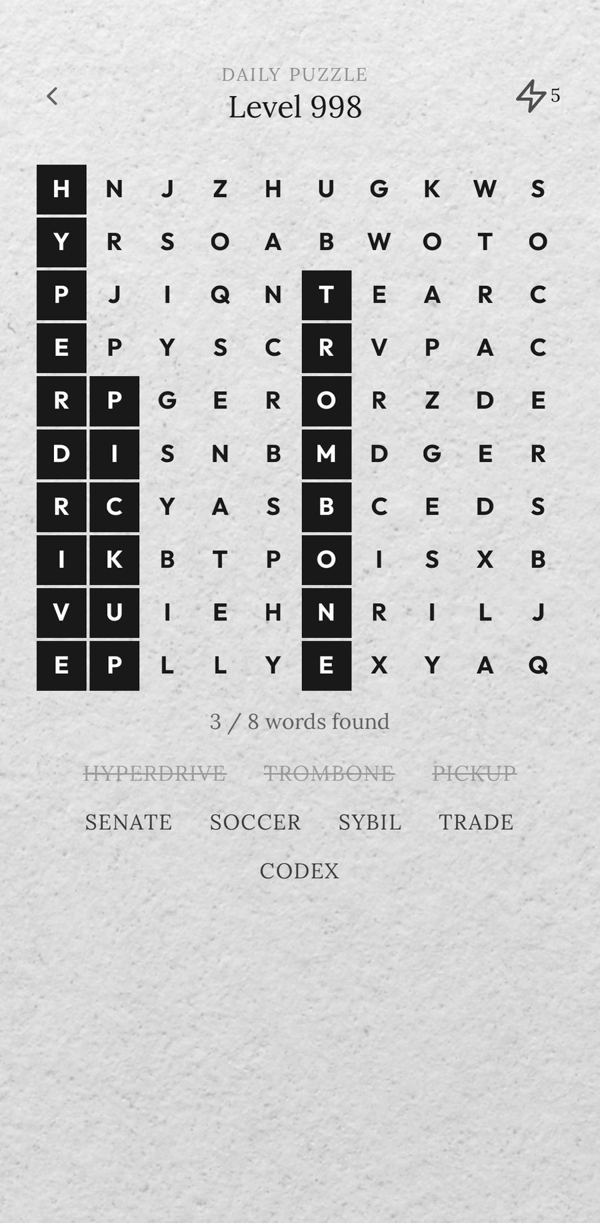 A puzzle in progress, three words found as black tiles